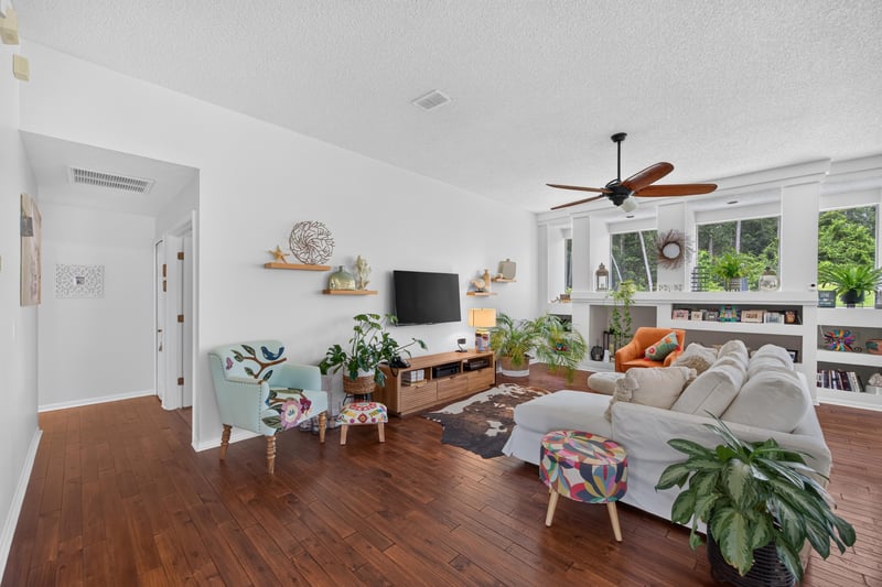 Living room with built-in shelving and ceiling fan at 1820 Burgess Hill Dr E, Jacksonville, FL