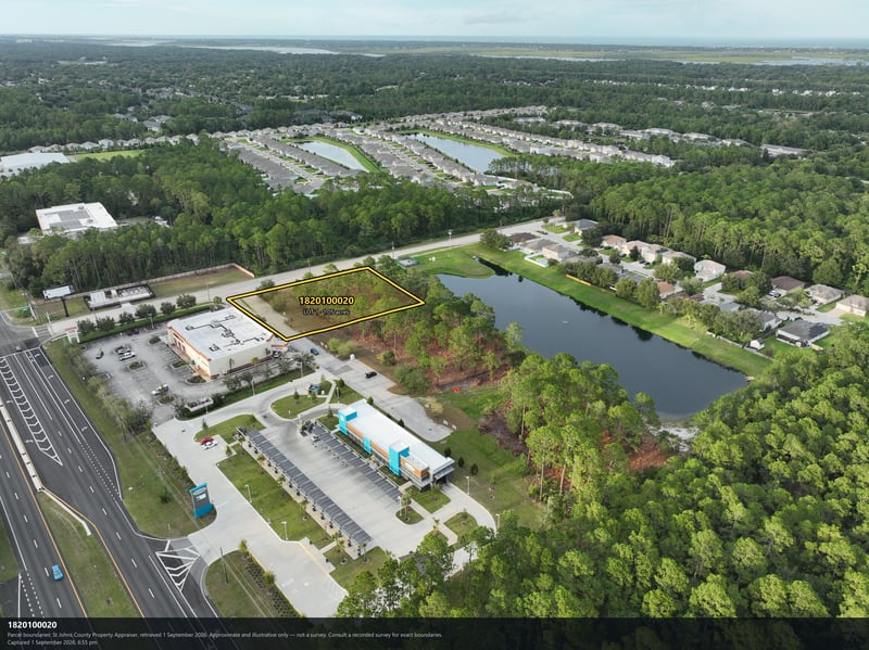 Aerial view of the pond, parking lot, and wooded parcel at 4900 US-1, St. Augustine, FL 32086