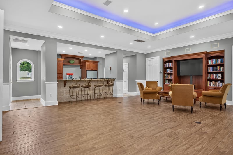 Clubhouse lounge with bookshelf and bar area in Mirabella Condo