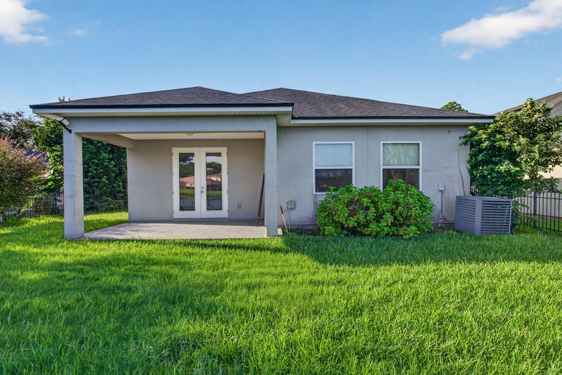 Rear exterior with covered patio and lawn at 13685 Goodson Pl, Jacksonville, FL 32226