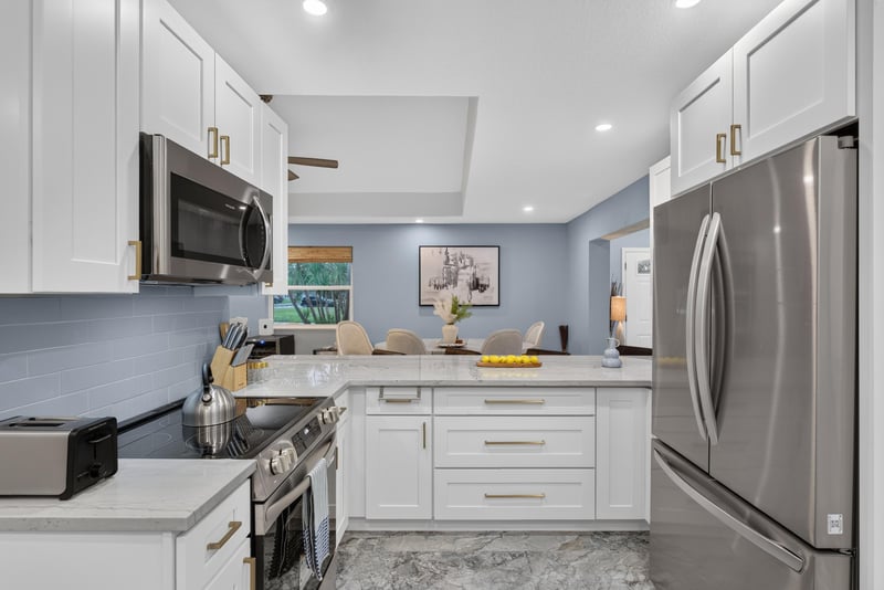 Kitchen with white cabinetry and tray ceiling at 1525 8th St N, Jacksonville Beach, FL