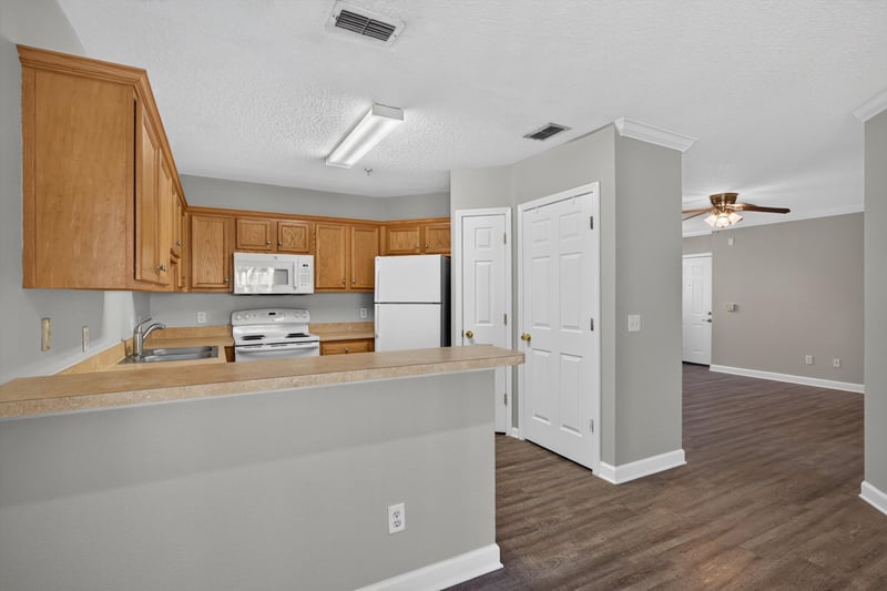 Kitchen with wood cabinets and appliances at 1701 The Greens Way 1415, Jacksonville Beach, FL 32250