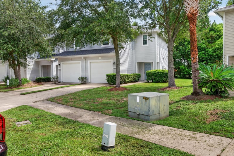 Front exterior with driveway and utility box at 12359 Mangrove Forest Ct, Jacksonville, FL 32218
