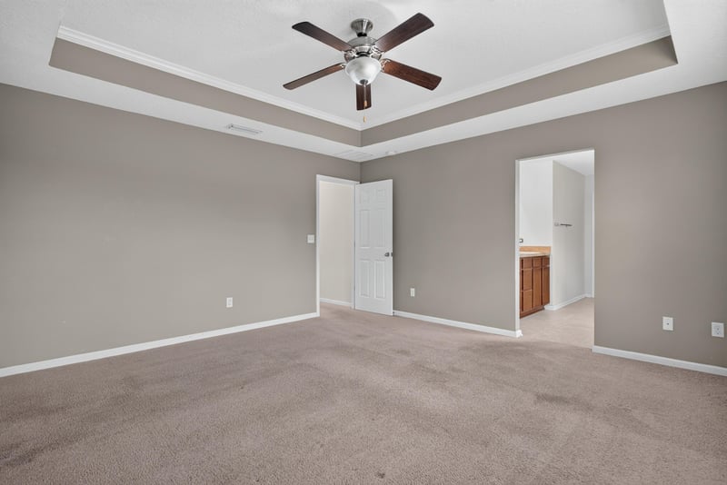 Primary bedroom with tray ceiling and carpet at 263 Gilmore Ln, Orange Park, FL 32065
