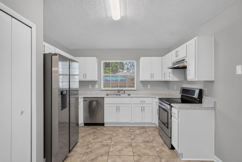 Kitchen with white cabinets and stainless refrigerator at 1108 Hidden Cove Cir S, Atlantic Beach, FL 32233