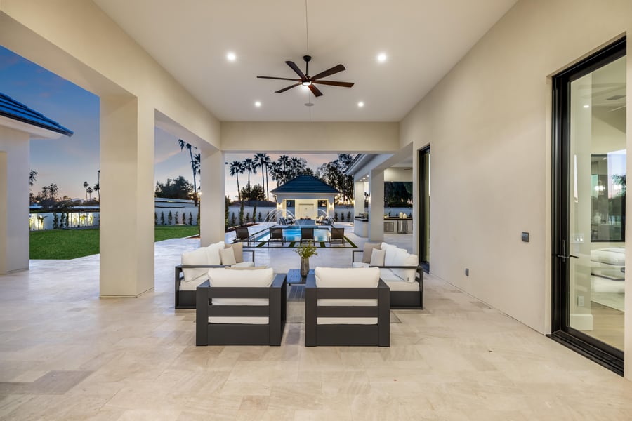 Covered patio with lounge seating looking out to the pool and casita