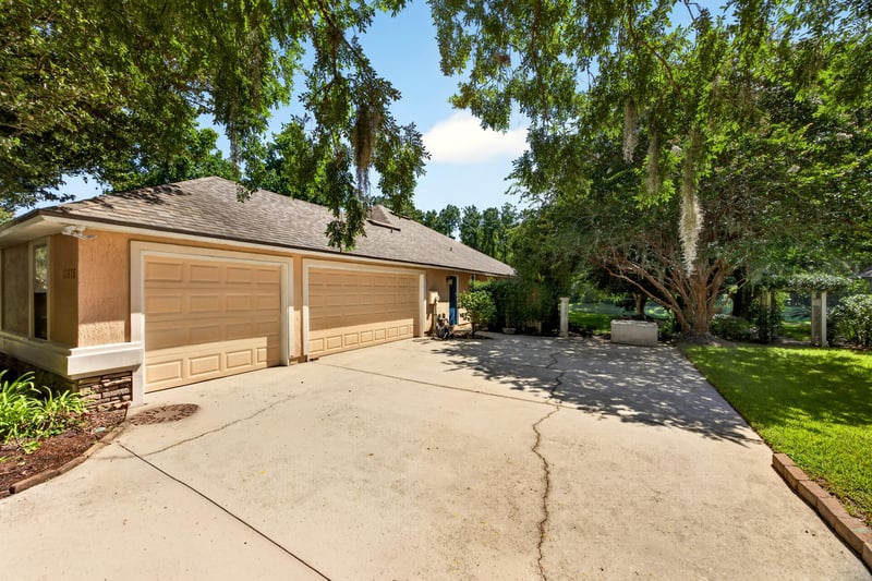 Front exterior with three-car garage and driveway at 11675 Magnolia Estates Rd, Jacksonville, FL 32223