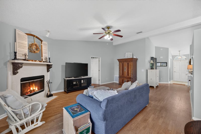 Family room with fireplace and wicker chair at 4556 Shaky Leaf Ln N, Jacksonville, FL 32224