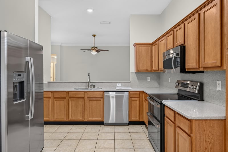 Kitchen with refrigerator and tile floor at 2131 E Stone Creek Dr, Fleming Island, FL