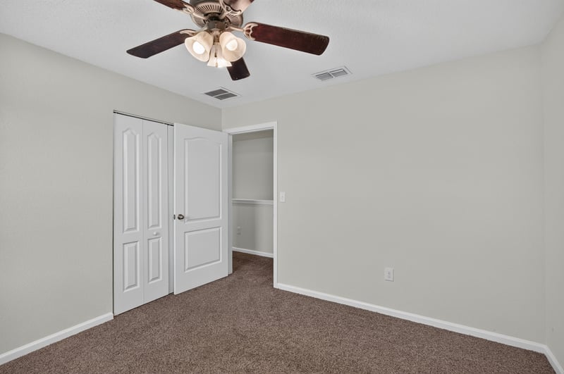 Bedroom with closet doors and ceiling fan at 6830 Hanford St, Jacksonville, FL 32219