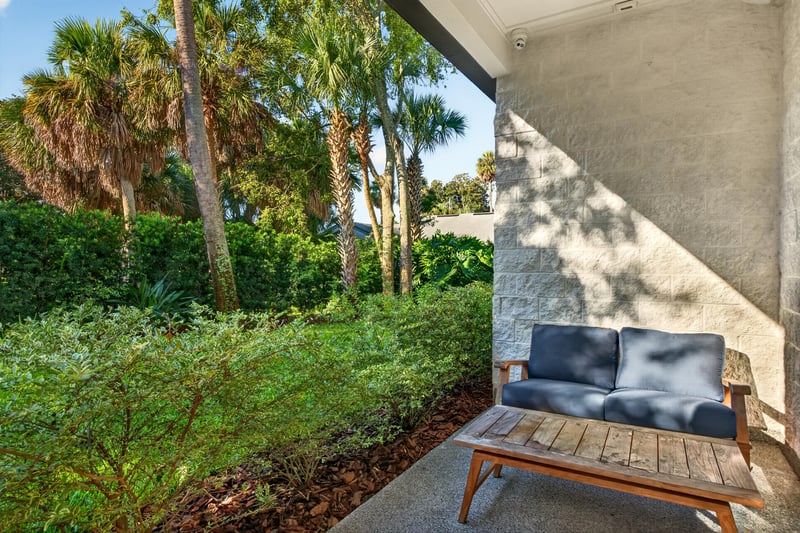 Side yard with covered stairway and mature trees at 722 3rd Ave N, Jacksonville Beach, FL