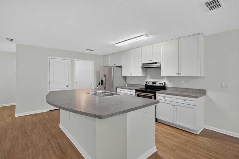 Kitchen island with stainless refrigerator at 95221 Siena Ct, Fernandina Beach, FL 32034