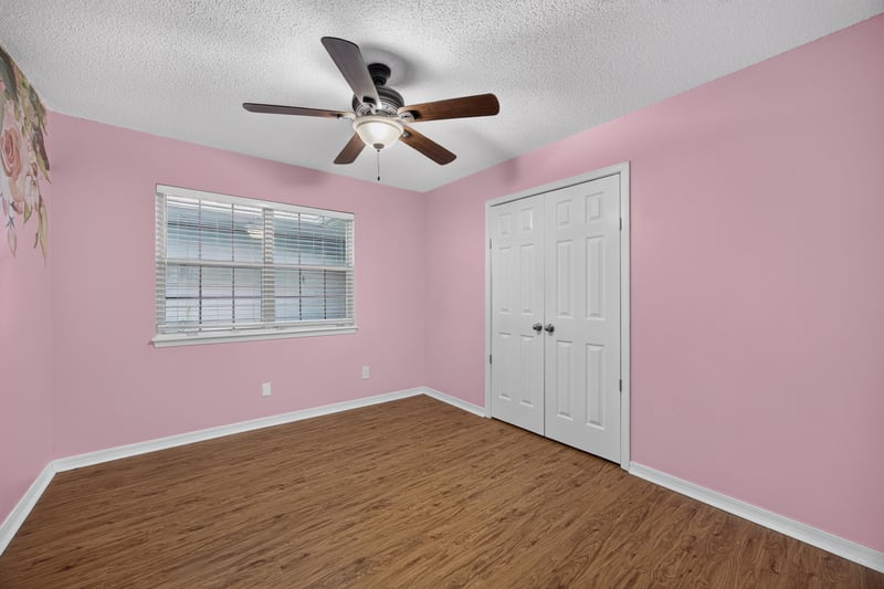 Bedroom with pink walls and ceiling fan at 892 Branscomb Rd, Green Cove Springs, FL