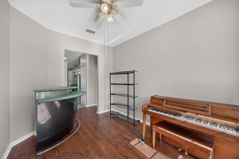 Music room with piano and open shelving at 11828 Heather Grove Ln, Jacksonville, FL