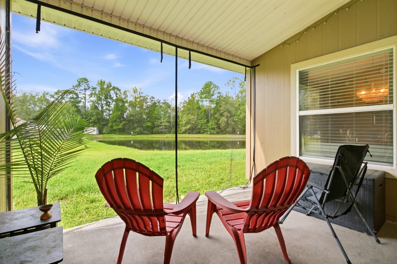 Screened porch with red chairs at 7392 Timber Falls Ct