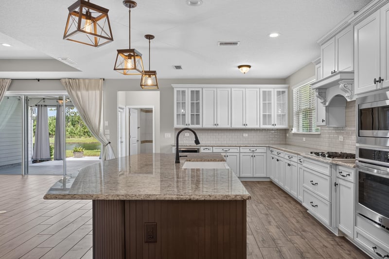 Kitchen with island, pendant lights and sliding glass door at 53 Lumen Ct, St. Augustine, FL 32095