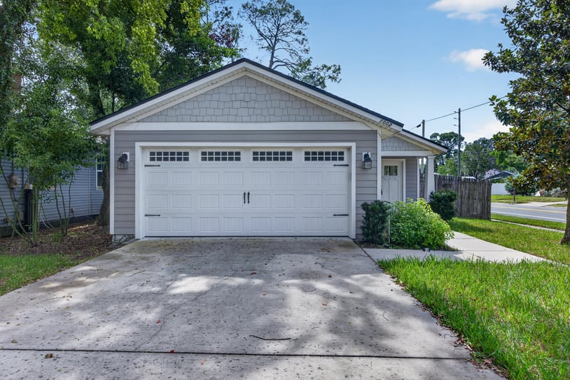 Front exterior with white garage door and driveway at 1002 Ingleside Ave, Jacksonville, FL 32205