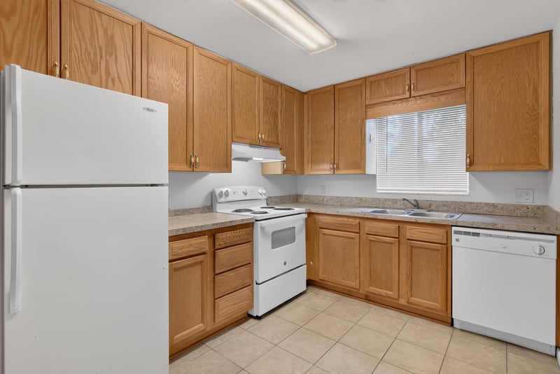 Kitchen with white refrigerator and oak cabinets at 2618 Arlex Dr E, Jacksonville, FL