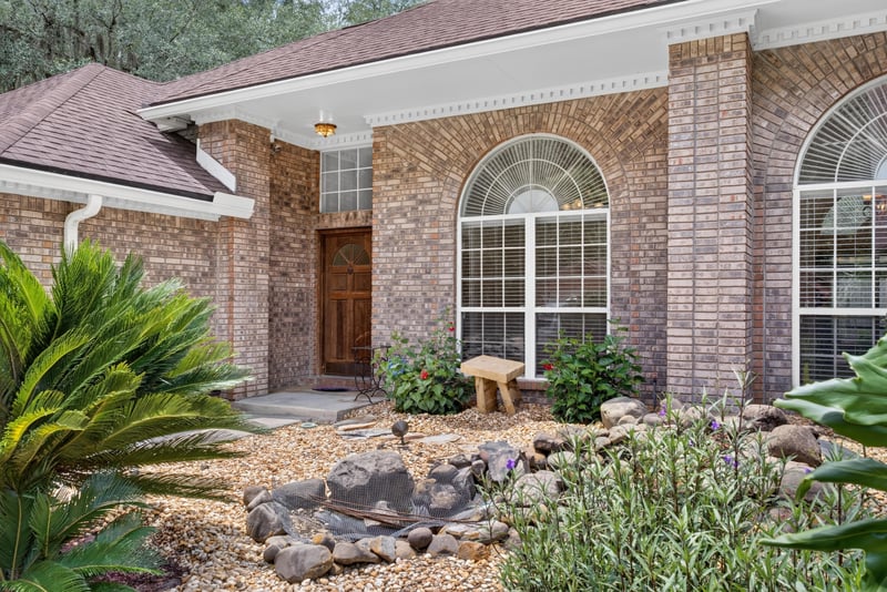 Front entry with arched window and rock landscaping at 12810 Swamp Owl Ln