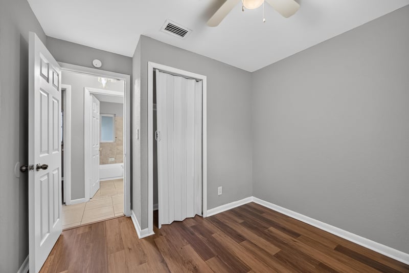 Hallway with closet doors and wood-look floor at 4030 Leonard Cir W, Jacksonville, FL 32209