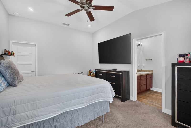 Primary bedroom with ceiling fan and dresser at 9846 Olivia St, Jacksonville, FL