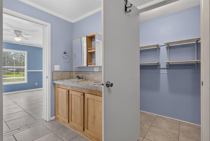 Bathroom with door open to walk-in closet at 2549 Snapdragon Ave, Middleburg, FL 32068