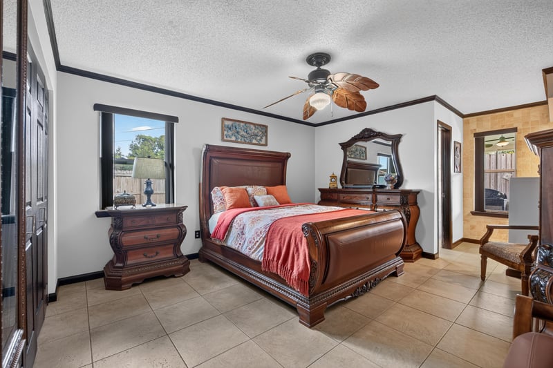 Bedroom with wood bed frame and dresser at 6931 Cane Grass Ln E, Jacksonville, FL 32244