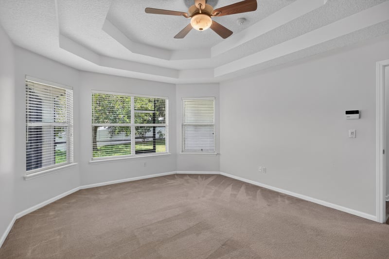Bedroom with tray ceiling and windows at 2480 Ridge Will Dr, Jacksonville, FL 32246