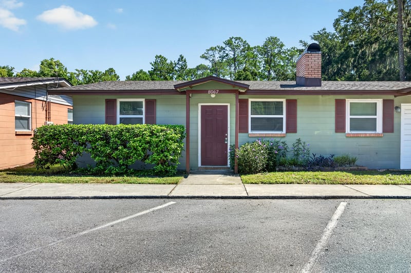 Front exterior view from parking area with brick chimney at 8067 Parental Cir, Jacksonville, FL 32216