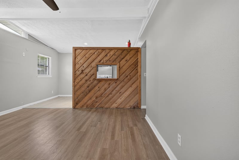 Living room with wood accent wall and wood-look flooring at 255 Woodside Dr, Orange Park, FL 32073