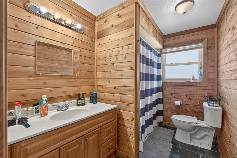 Bathroom with wood paneling and tub shower at 6059 Karen St, Jacksonville, FL 32244