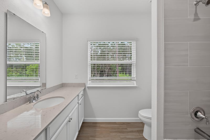 Bathroom vanity with wood-look flooring, virtually staged at 9905 Ansley Lake Dr, Jacksonville, FL