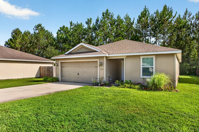 Front exterior with landscaping and pine trees at 518 Matecumbe Ct, Macclenny, FL
