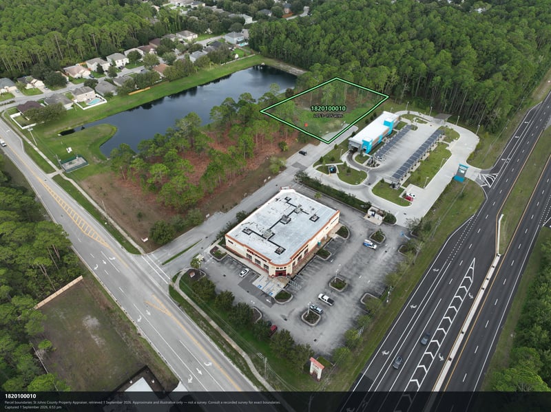 Aerial view of the highway, pond, and tree-lined parcel at 4900 US-1, St. Augustine, FL 32086