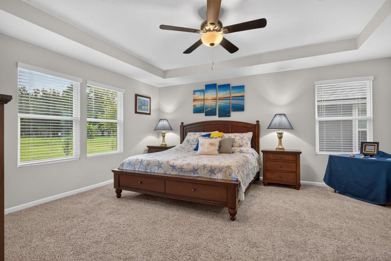 Primary bedroom with tray ceiling and wood bed at 4319 Green River Pl, Middleburg, FL 32068