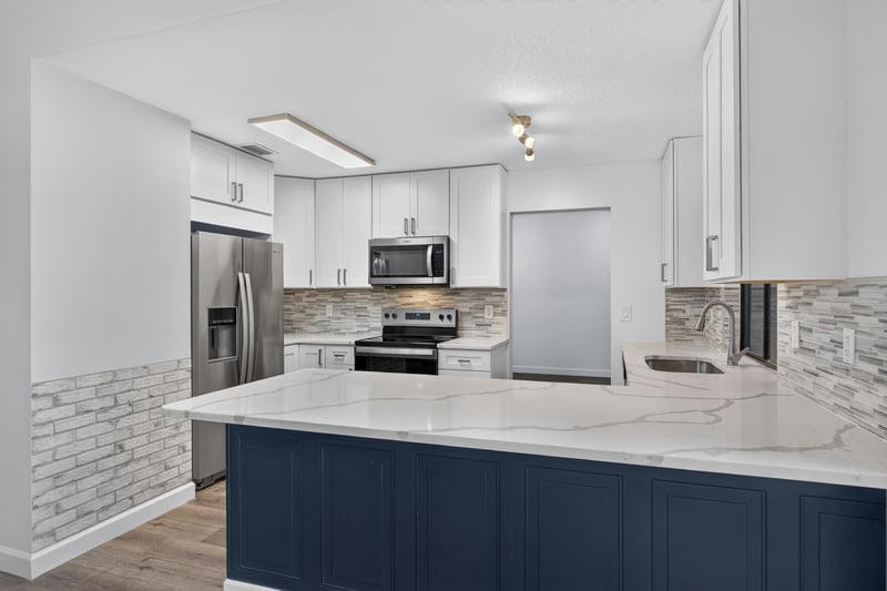 Kitchen with white cabinets and stainless refrigerator at 551 Deltona Blvd, St. Augustine, FL 32086