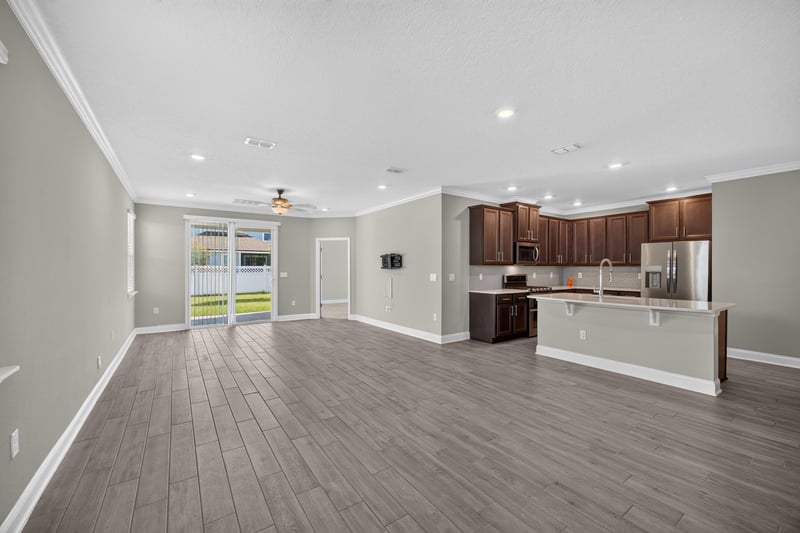 Living room with wood-look floors and kitchen view at 331 Millerstone Dr, St. Augustine, FL 32092