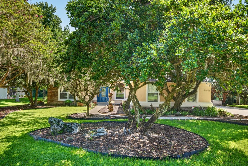 Aerial of the home among trees with a neighboring pool in the distance at 11675 Magnolia Estates Rd, Jacksonville, FL 32223