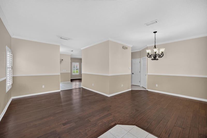 Empty room with wood floors and chandelier at 1493 Greyfield Dr, St. Augustine, FL 32092