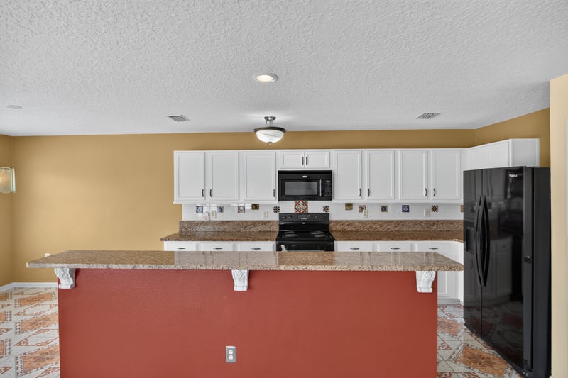 Kitchen island with bar seating and tile floor at 2282 Justin Lake Dr, Jacksonville, FL