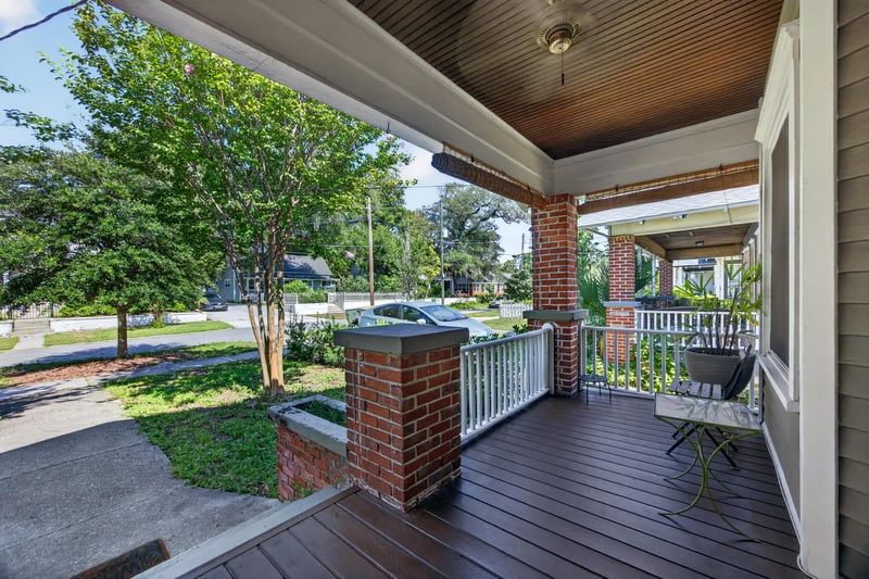 Front porch seating area with street view through trees at 1555 Belmonte Ave, Jacksonville, FL 32207