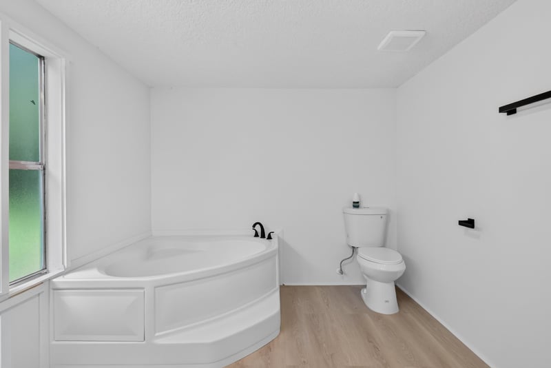 Primary bathroom with soaking tub and window at 55520 Jewel-Thomas Rd, Callahan, FL 32011