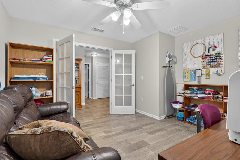 Family room with leather sofa and French doors at 4319 Green River Pl, Middleburg, FL 32068