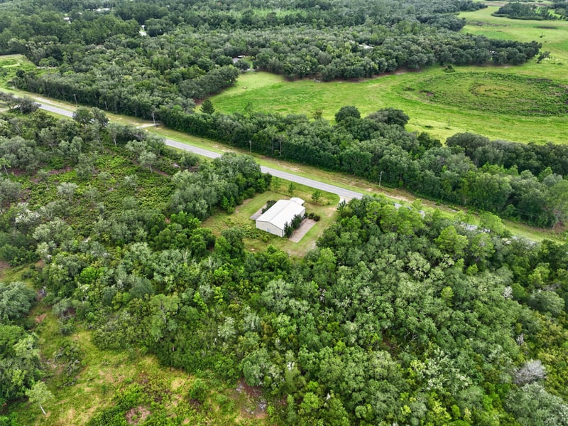 Drone aerial of the building set among trees at 1038 County Rd 315, Melrose