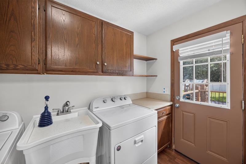 Laundry room with utility sink and door to deck at 892 Branscomb Rd, Green Cove Springs, FL