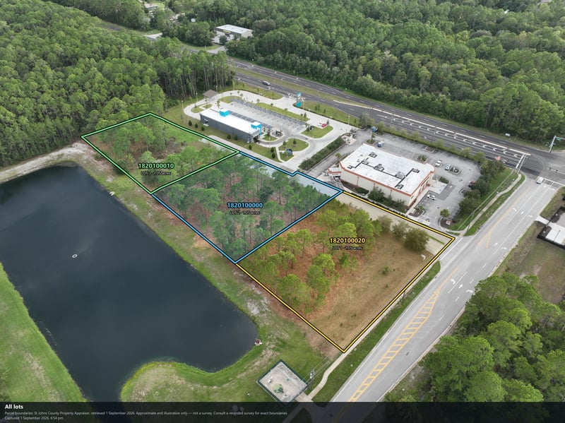 Aerial view of the tree-lined parcel next to a parking lot and pond at 4900 US-1, St. Augustine, FL 32086