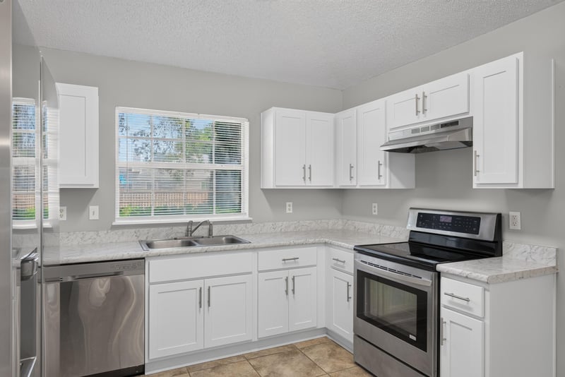 Kitchen with white cabinets and windows over sink at 1108 Hidden Cove Cir S, Atlantic Beach, FL 32233
