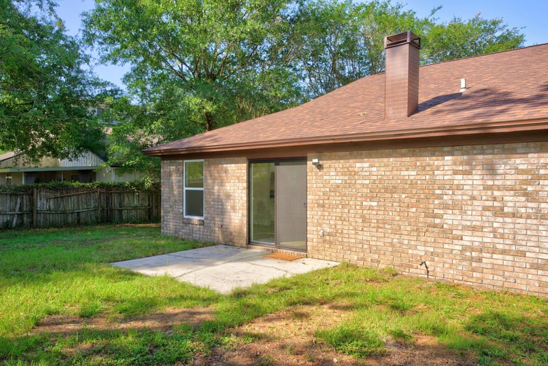 Back exterior with brick facade and chimney at 8453 Boysenberry Ln W, Jacksonville, FL
