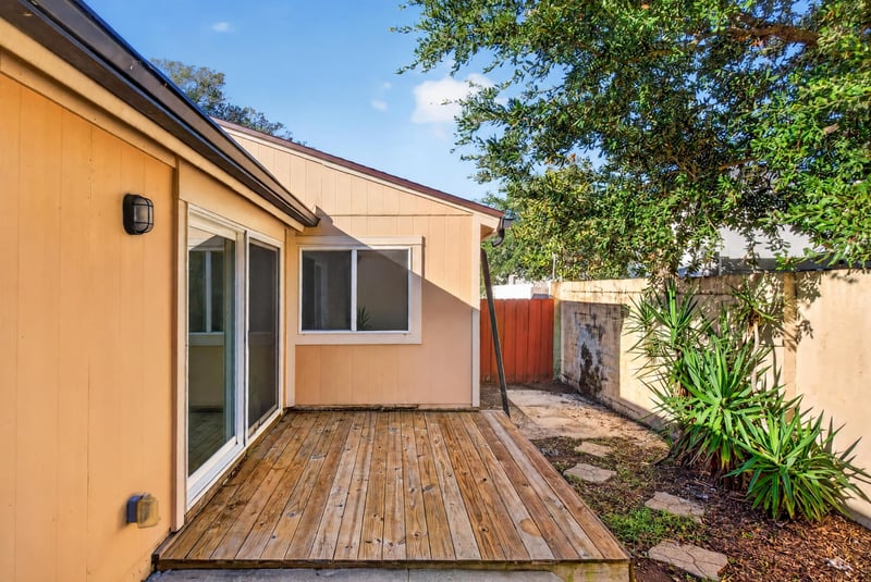 Rear exterior with wood deck and sliding glass door at 8177 Virgo St, Jacksonville, FL 32216