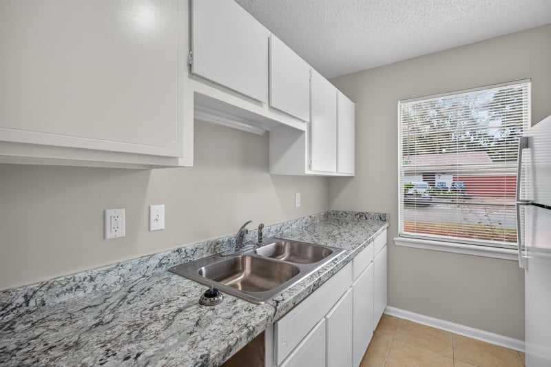 Kitchen sink with granite counter and window at 1040 Willow Cove Ct E, Jacksonville, FL 32233